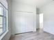 Bright bedroom with wood-look floors, large closet, and door leading to the hallway at 16121 Sw 37Th Terrace Rd, Ocala, FL 34473