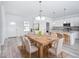 Dining area showcases a large wooden table with seating, chandelier, and modern kitchen nearby at 16121 Sw 37Th Terrace Rd, Ocala, FL 34473