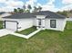New construction featuring a well-manicured lawn and concrete walkway leading to the front door at 16121 Sw 37Th Terrace Rd, Ocala, FL 34473