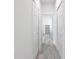 Hallway featuring wood-look floors, white walls, and closet space, leading to another room at 16121 Sw 37Th Terrace Rd, Ocala, FL 34473