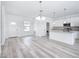 Open-concept living space with wood-look floors, white walls, and a view of the kitchen at 16121 Sw 37Th Terrace Rd, Ocala, FL 34473