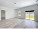 Spacious living room with natural light, wood floors, a window, and sliding glass doors to backyard at 16121 Sw 37Th Terrace Rd, Ocala, FL 34473