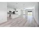Bright, open-concept floor plan with kitchen island, stainless appliances, light wood floors, and dining area at 16121 Sw 37Th Terrace Rd, Ocala, FL 34473
