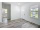 An open-concept living room featuring a new door, new window, and new light wood-look floors at 16121 Sw 37Th Terrace Rd, Ocala, FL 34473