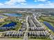 Aerial view of a neighborhood with homes surrounding a lake and green spaces on a sunny day at 17055 Wynford Ln, Winter Garden, FL 34787