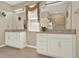 Bathroom featuring a double vanity with granite countertop and stylish mirrors at 17055 Wynford Ln, Winter Garden, FL 34787