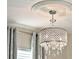 Stylish chandelier with crystal pendants and intricate ceiling trim at 17055 Wynford Ln, Winter Garden, FL 34787