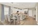 Open concept dining area featuring modern lighting, a large table set, and seamless access to the kitchen and living space at 17055 Wynford Ln, Winter Garden, FL 34787