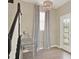 Elegant entryway with decorative door, chandelier, mirrored table and wood flooring at 17055 Wynford Ln, Winter Garden, FL 34787