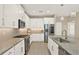 Modern kitchen featuring granite countertops, stainless steel appliances, and ample white cabinetry for storage at 17055 Wynford Ln, Winter Garden, FL 34787
