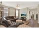 Spacious living room featuring a comfortable leather sectional sofa, stylish chandelier, and hardwood floors at 17055 Wynford Ln, Winter Garden, FL 34787