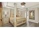 Luxurious main bedroom with a four-poster bed, elegant furnishings, and tray ceiling with modern lighting at 17055 Wynford Ln, Winter Garden, FL 34787