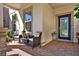 Cozy front porch seating area with brick flooring, comfortable chairs, a small table, and a decorative front door at 17055 Wynford Ln, Winter Garden, FL 34787