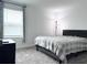 Bright bedroom featuring plush carpeting and a comfortable bed with neutral-toned linens at 1902 Presley Pl, Kissimmee, FL 34746