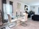 Modern dining room featuring a glass-top table and leather chairs, flowing into the living room at 1902 Presley Pl, Kissimmee, FL 34746