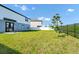 This large backyard features a lush lawn, tree, and black fence, creating a relaxing, secure oasis at 2126 Derwent Dr, Davenport, FL 33896