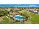 Community pool surrounded by palm trees and green space at 2126 Derwent Dr, Davenport, FL 33896