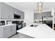 Modern kitchen featuring gray cabinetry, stainless steel appliances and a bright white countertop island at 2126 Derwent Dr, Davenport, FL 33896