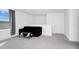 Bright living room with comfortable black love seat, cow hide ottoman, and a window at 2126 Derwent Dr, Davenport, FL 33896
