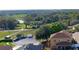 Aerial view of the surrounding neighborhood with lush landscape including a lake and other residential homes at 25012 Chipshot Ct, Sorrento, FL 32776