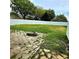 Large backyard featuring a stone fire pit and a well-maintained privacy fence at 25012 Chipshot Ct, Sorrento, FL 32776