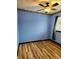 Bedroom featuring wood floors, blue walls, and a ceiling fan with lights at 25012 Chipshot Ct, Sorrento, FL 32776