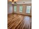 Bright bedroom featuring wood floors and three windows at 25012 Chipshot Ct, Sorrento, FL 32776