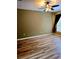 Bedroom showcasing wood-look flooring, ceiling fan, and a window with curtains at 25012 Chipshot Ct, Sorrento, FL 32776
