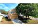 Two-story home with a tan exterior, attached garage, and a long driveway at 25012 Chipshot Ct, Sorrento, FL 32776