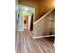 Hallway with light brown wood flooring and neutral-toned walls, featuring stairs leading up at 25012 Chipshot Ct, Sorrento, FL 32776