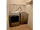 Laundry room with a washer and dryer, tile floor, and storage shelves at 25012 Chipshot Ct, Sorrento, FL 32776
