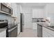 Stylish kitchen with stainless steel appliances, white cabinetry, and a gray tile backsplash at 2750 Slash Way, St Cloud, FL 34771