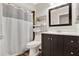 Bathroom featuring a shower with curtain, vanity with dark wood cabinets, and a decorative storage shelf at 31024 Prestwick Ave, Sorrento, FL 32776