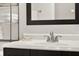 A close up of a bathroom faucet and vanity with a dark wood cabinet, a mirror, and chrome shelves at 31024 Prestwick Ave, Sorrento, FL 32776