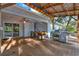 Outdoor dining area on the backyard covered deck with stainless steel grill and fan at 31024 Prestwick Ave, Sorrento, FL 32776