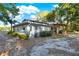 Charming home exterior featuring a deck, large yard, and mature trees at 31024 Prestwick Ave, Sorrento, FL 32776