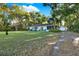 Charming one-story home with well-maintained lawn, mature palm trees and a long driveway at 31024 Prestwick Ave, Sorrento, FL 32776