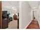 Hallway leading to a bedroom with a desk, chair, and bed under a ceiling fan and natural light at 31024 Prestwick Ave, Sorrento, FL 32776