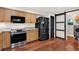 Well-lit kitchen with stainless steel appliances, wood cabinets, and a sliding barn door at 31024 Prestwick Ave, Sorrento, FL 32776