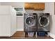 Convenient laundry room featuring modern washer and dryer next to the refrigerator and storage cabinets at 31024 Prestwick Ave, Sorrento, FL 32776