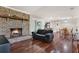 Spacious living room featuring a brick fireplace, hardwood floors, and an open layout at 31024 Prestwick Ave, Sorrento, FL 32776