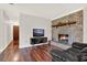 Inviting living room with a brick fireplace, hardwood floors, and modern entertainment center at 31024 Prestwick Ave, Sorrento, FL 32776