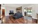Cozy living room with a brick fireplace, hardwood floors, and access to the outdoor patio at 31024 Prestwick Ave, Sorrento, FL 32776