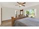 Bright main bedroom featuring a ceiling fan, a wooden headboard, and a large window offering natural light at 31024 Prestwick Ave, Sorrento, FL 32776