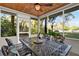 Enjoy outdoor dining in this screened porch with a ceiling fan, wood ceiling, and neighborhood views at 31024 Prestwick Ave, Sorrento, FL 32776
