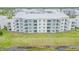 Exterior of a large condo building features white and blue facade and multiple balconies with green space at 3121 Paradox Cir # 307, Kissimmee, FL 34746