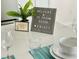 Charming kitchen decor with welcome sign, decorative plant, plates and wine glasses on the counter at 3121 Paradox Cir # 307, Kissimmee, FL 34746