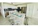Bright kitchen features white cabinetry, stainless appliances, an island, and barstool seating at 3121 Paradox Cir # 307, Kissimmee, FL 34746