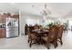 Elegant dining area open to kitchen featuring dark wood table and modern stainless steel appliances at 3244 Amaca Cir, Orlando, FL 32837