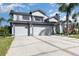 Inviting two-story home with a manicured lawn, garden beds, and a three-car garage at 3244 Amaca Cir, Orlando, FL 32837